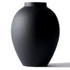 A smooth, matte black modern round metal decorative vase viewed from the side.