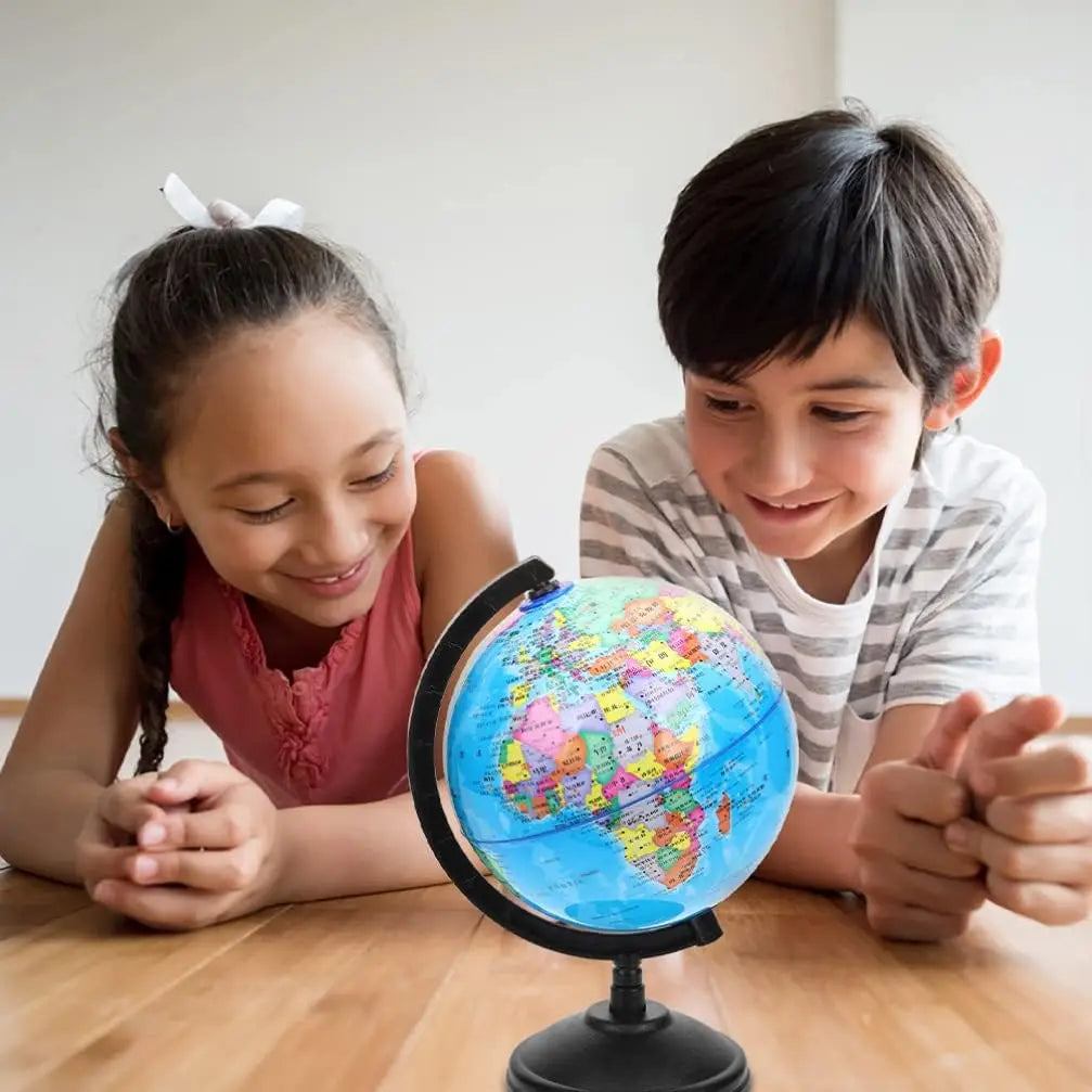 A young girl and boy looking at a desktop educational globe with an HD English world map.