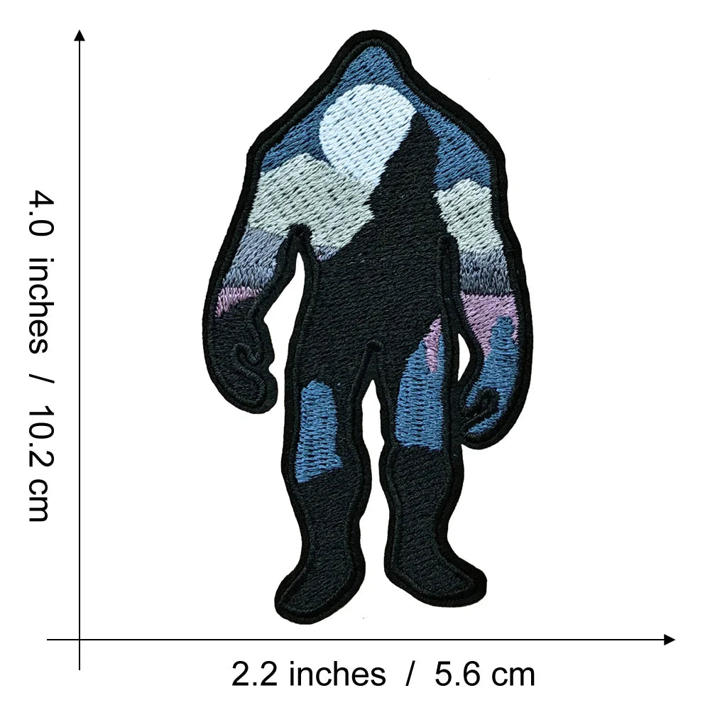 A black embroidered patch depicting the silhouette of Bigfoot against a light blue and gray background.