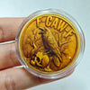 A gold-colored challenge coin featuring a crow perched on a skull design.