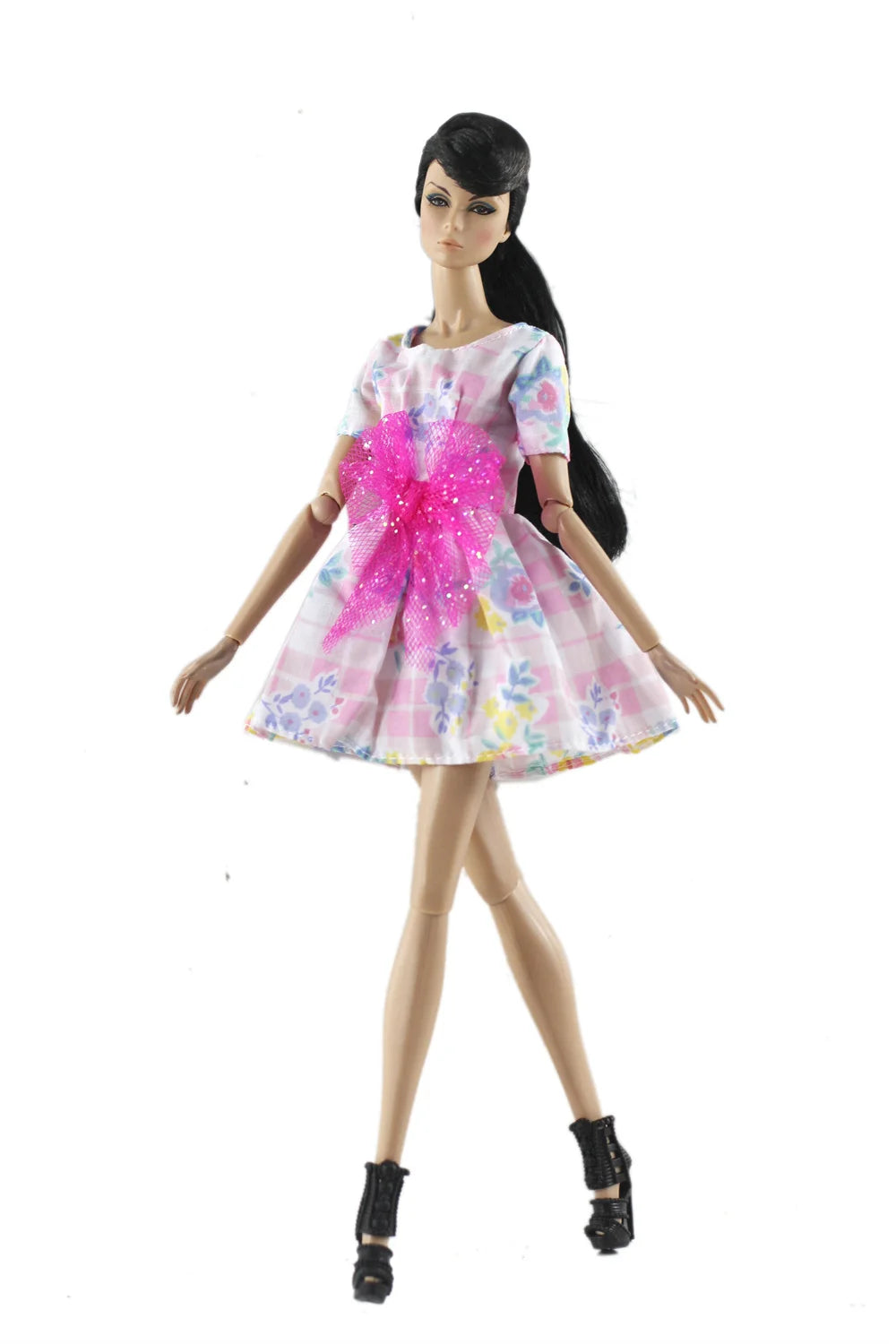 A handmade doll dress gown featuring pink and purple floral patterns with bright pink glitter accents.