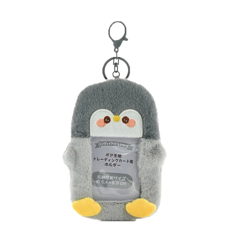 A gray penguin keychain featuring a cute face and yellow feet.