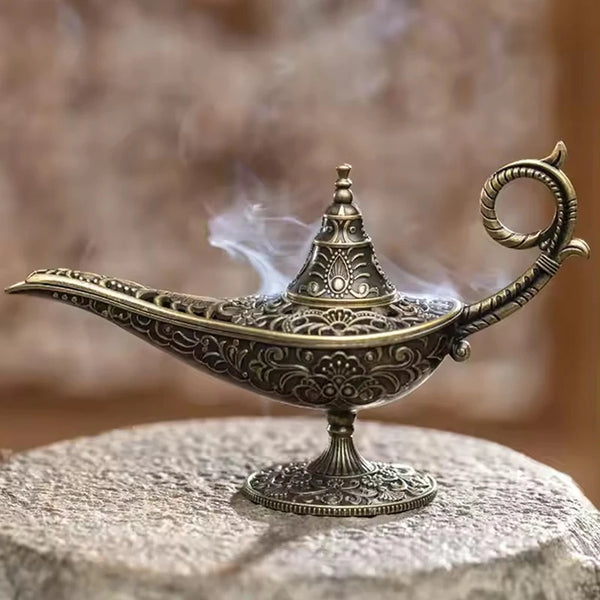 مبخرة معدنية قديمة بتصميم مزخرف تنبعث منها دخان على سطح حجر.