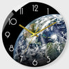A black round wall clock face showing a view of Earth with the hands pointing to approximately 1:30.