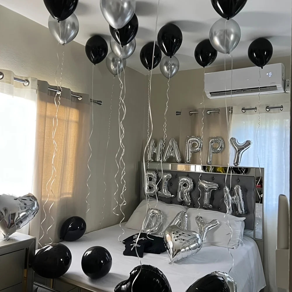 Silver alphabet and heart balloon set hanging above a bed for party decorations