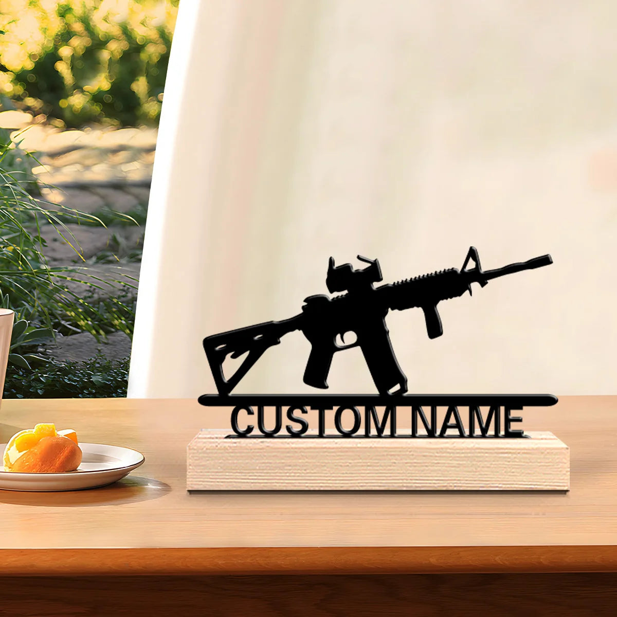 A black metal rifle statue with a wooden base is displayed on a wooden desk.