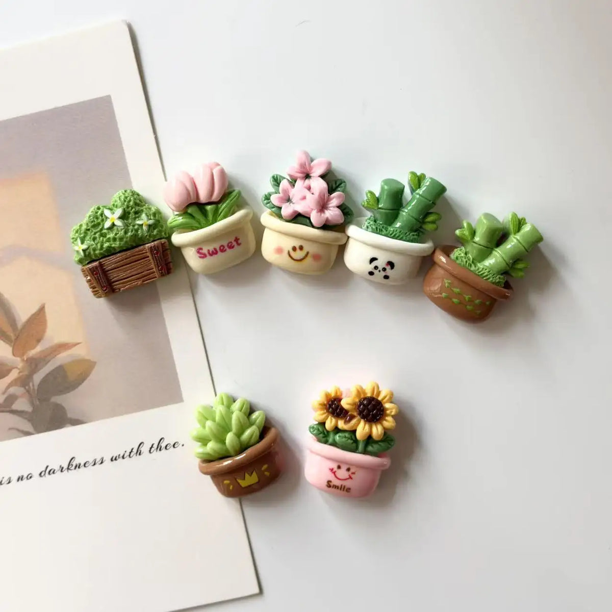 A set of six small cactus and flower potted magnets in various pastel green and pink colors for desktop decor