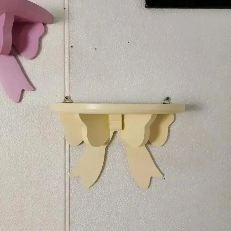 A light beige wooden bow-shaped shelf mounted on a white wall.