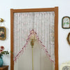 A sheer lace door curtain with pink embroidery and tassels hanging in a wooden frame.