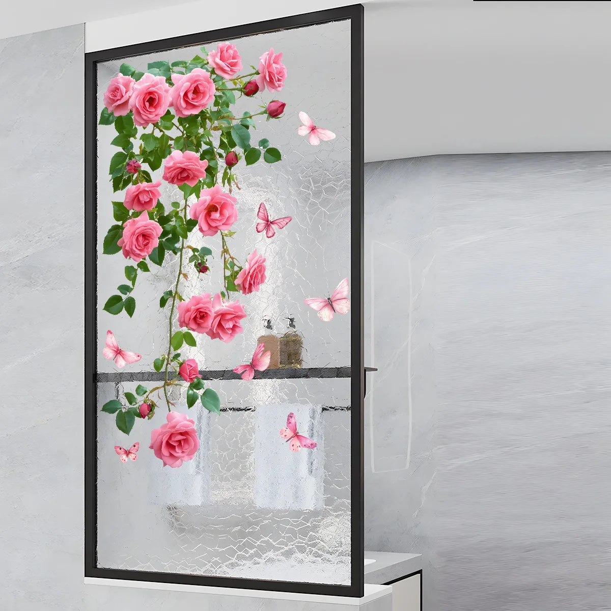 A framed floral window decal featuring pink roses and butterflies on a glass surface.