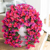 A vibrant artificial bougainvillea vine garland featuring bright pink and purple flowers displayed in a white pedestal.