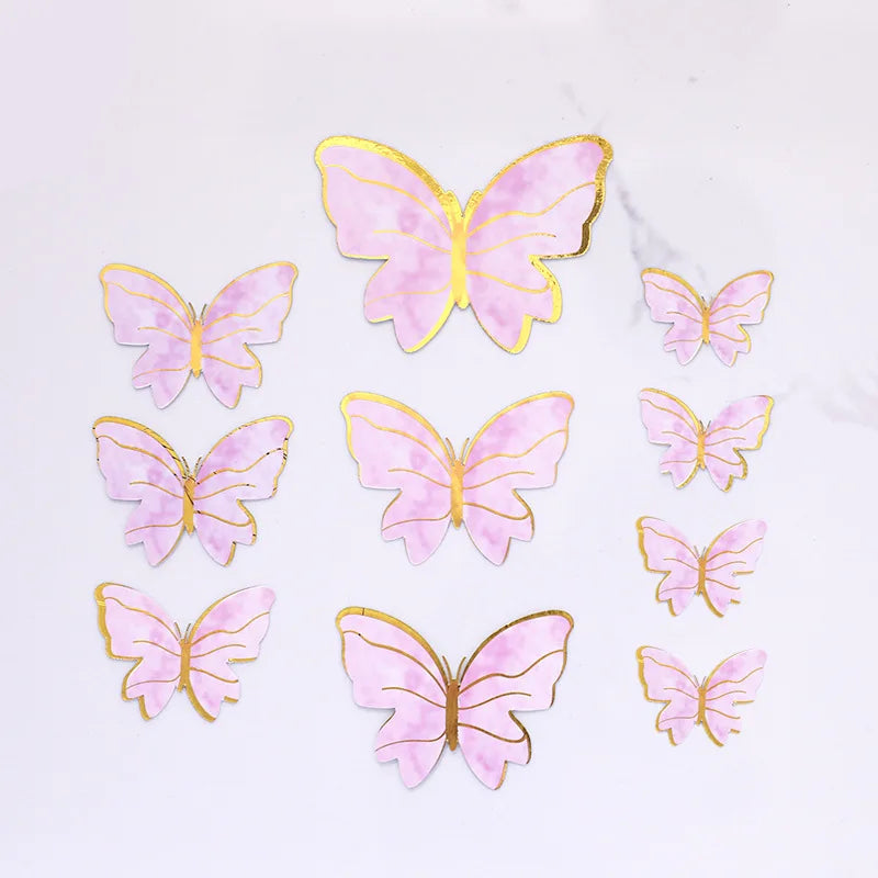 A collection of pink and gold butterfly cake toppers for parties and baking.