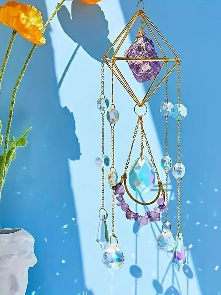 A hanging amethyst crystal suncatcher with golden accents, featuring various clear and purple beads.