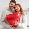 A couple holding a red heart foil balloon for Valentine's Day or wedding decorations.