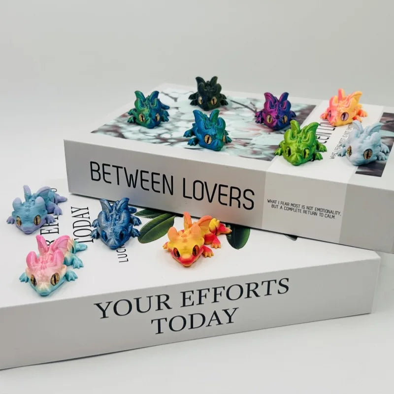 A set of six articulated baby dragon figurines in various colors displayed on a white box titled Between Lovers and Your Effo