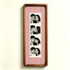 A wooden photo strip frame with a red and white striped background displaying several portrait photos of a couple.