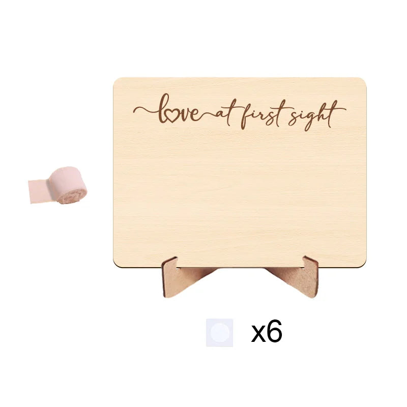 A light wood photo frame with cursive text 'love at first sight' and a ribbon, designed for pregnancy announcements.