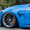 A close-up of a bright blue sports car featuring a Mexican Edition decal and aftermarket wheels.
