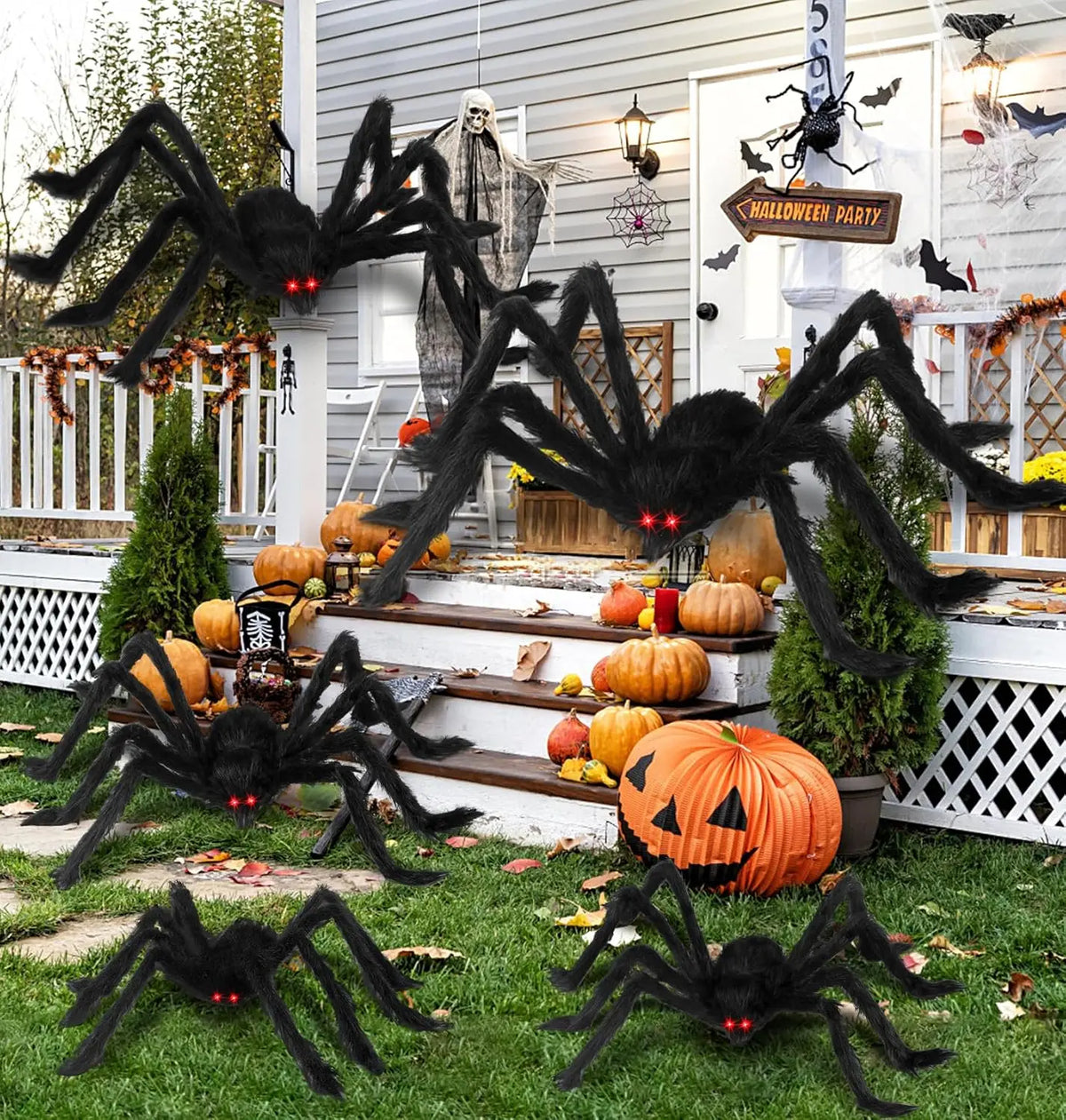 Giant black plush spider decoration hanging in front of a white door with Halloween decor.