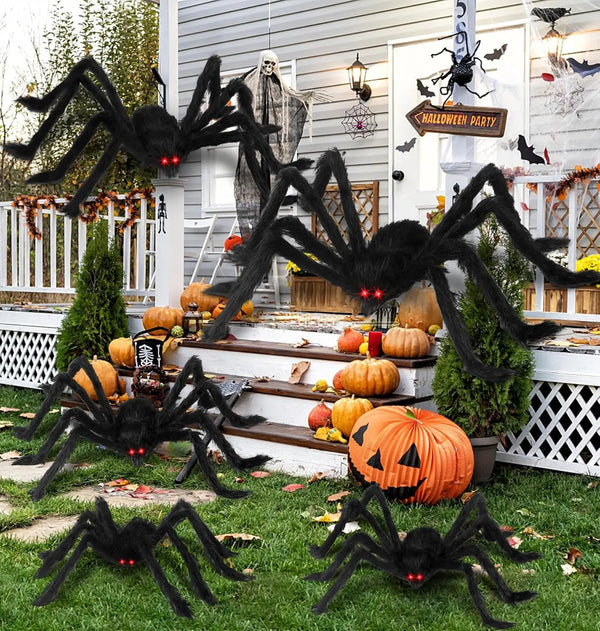 Giant black plush spider decoration hanging in front of a white door with Halloween decor.