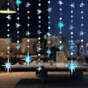 A vertical string of glittering star and polka dot lights hanging in the air.