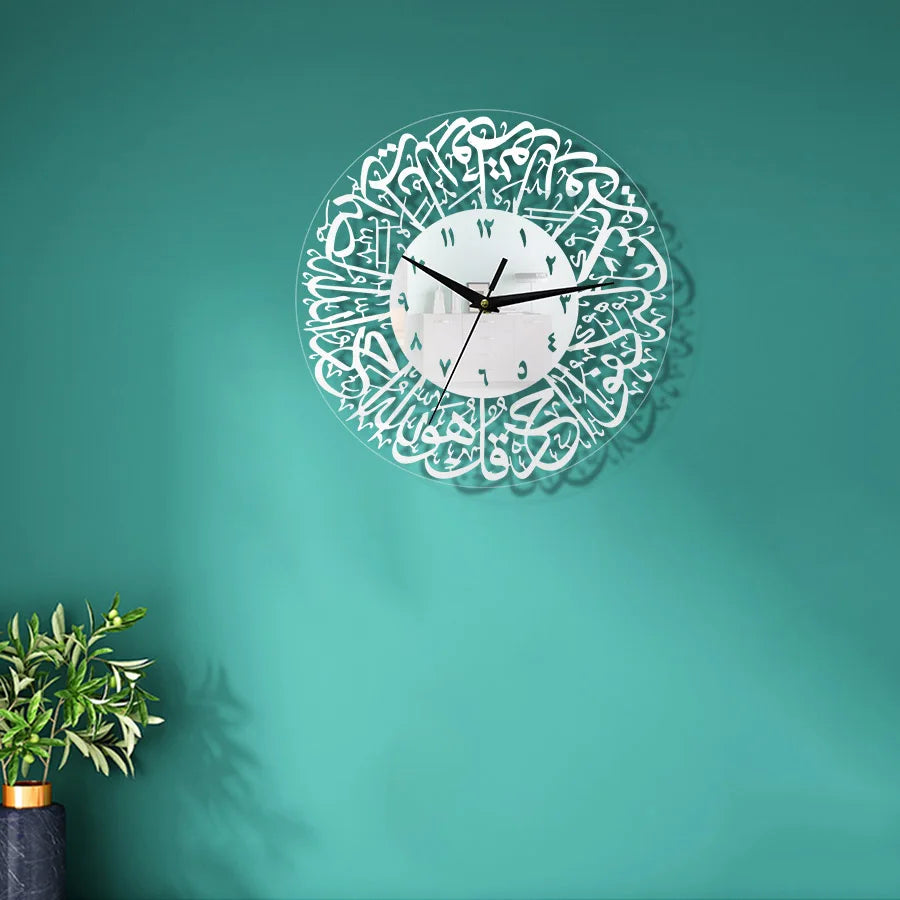 A white acrylic wall clock with intricate Arabic calligraphy design on a teal green wall.
