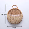 A woven natural fiber wall hanging basket with a handle, measuring 23.5cm by 18cm.