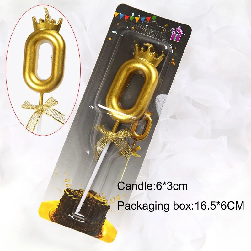 A gold crown number candle shaped like the number 0 is shown in a clear packaging box.
