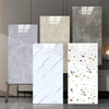 A display of various marble wall decals in different shades of gray and white on a wooden stand.