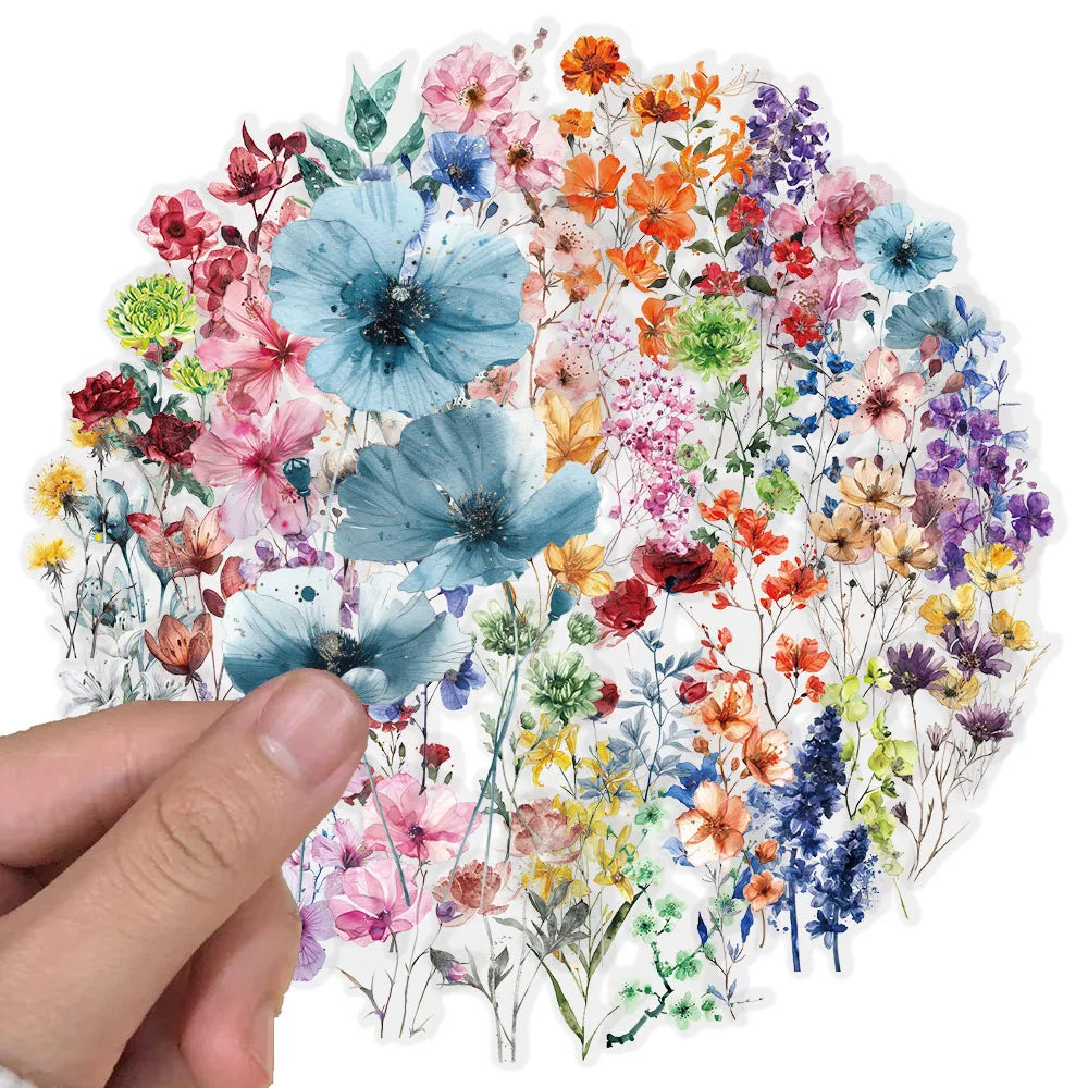 A hand holds a sheet of waterproof floral decal stickers featuring various colorful flowers on a transparent background.