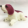 A white and maroon dog ornament figure lying down.