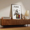 A framed canvas wall art featuring a portrait of a basketball player, Curry, with text and signature details.