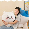 A woman is cuddling a white Usagi Chiikawa plush doll on a light-colored sofa.