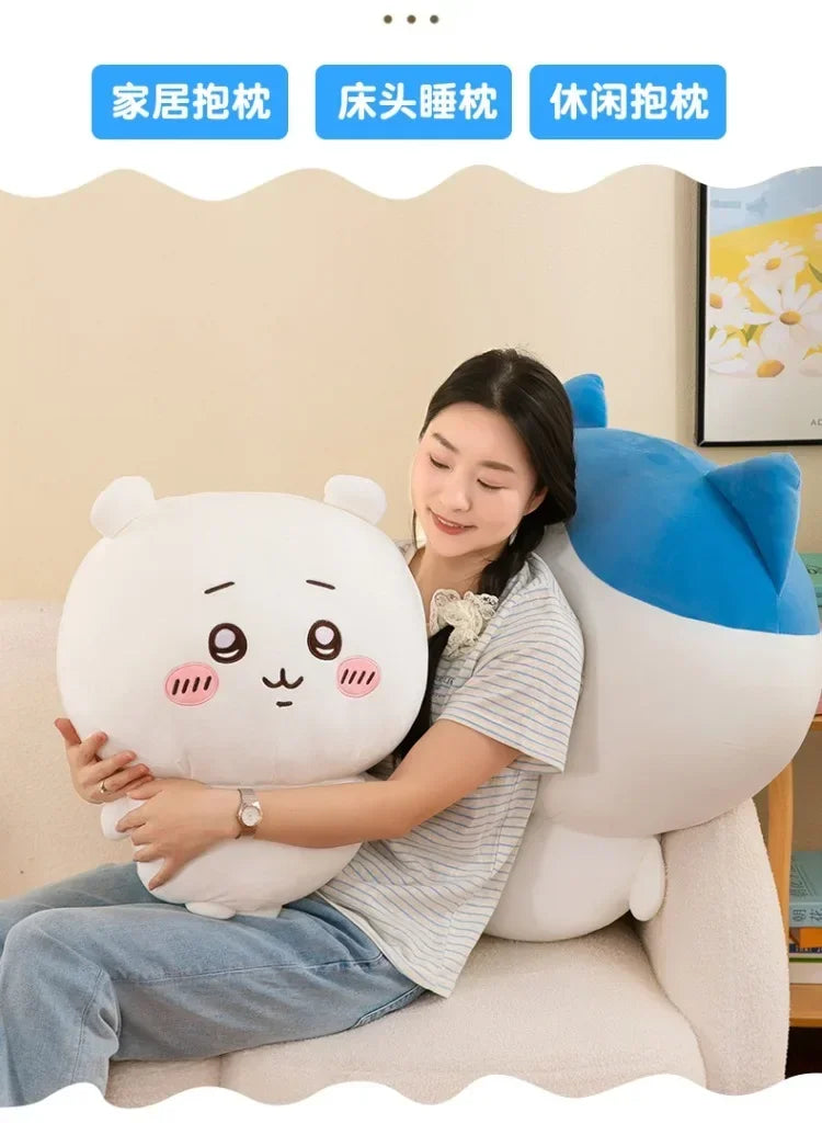 A woman is cuddling a white Usagi Chiikawa plush doll on a light-colored sofa.