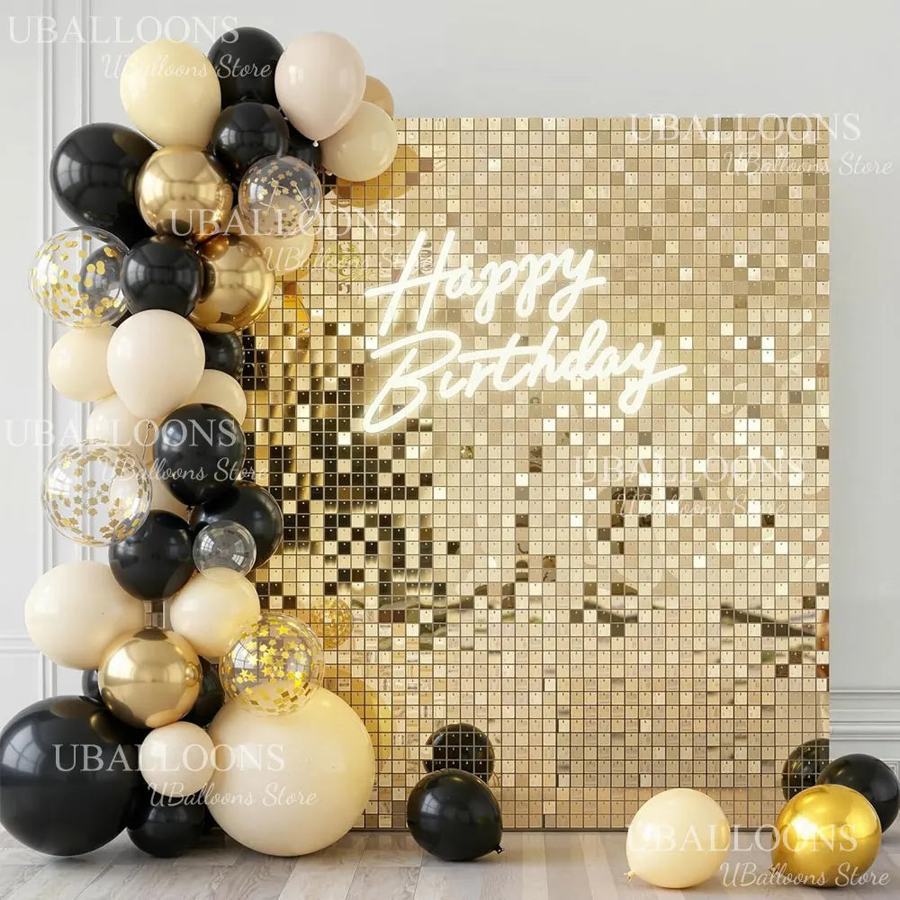 A gold and black balloon arrangement against a shimmering gold sequin wall backdrop with 'Happy Birthday' text.