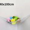 A white mesh storage hammock organizer for stuffed animals, displaying various colorful toys hanging on a wall.