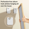 Two white perforation-free album hook photos hanging on a wall next to a wooden frame.