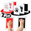 A set of handprint and footprint ink pads for babies, showing various prints on white cards and a baby's hand and foot.