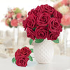 A bouquet of deep red foam roses in a white textured vase for wedding and home décor.