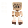 A small wooden figurine of a man with a circular face and arms, used as a desk decoration.