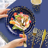 A hand is holding a gold spoon above a blue plate filled with fruit and salad, set against a dark blue background.