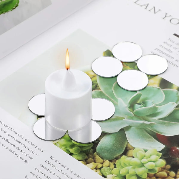 Una vela de pilar blanca colocada sobre un papel con una planta suculenta verde y texto.