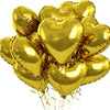 A bunch of shiny gold heart-shaped foil balloons tied together and floating.