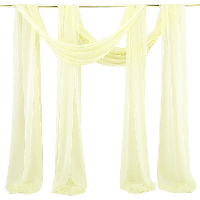A set of two sheer yellow chiffon fabric panels draped for a wedding arch backdrop.