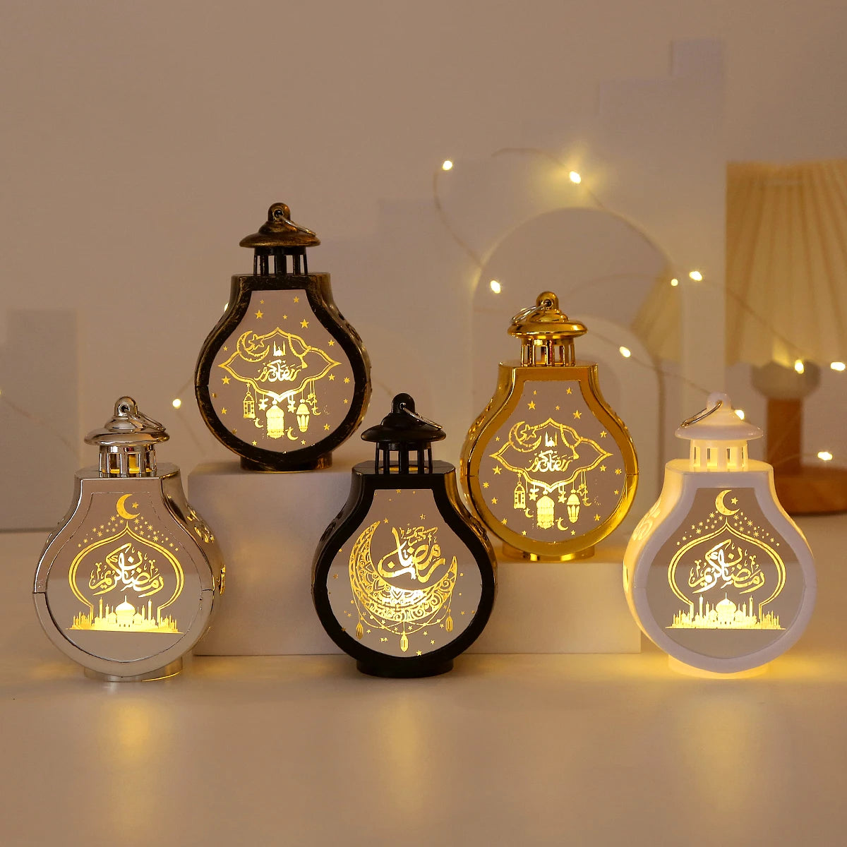 A collection of elegant LED star and moon lanterns in gold and black illuminating Islamic calligraphy.