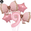 A set of pink bow shaped disposable party tableware, including star and spiral decorations.