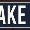 A dark metal sign with white text that reads ON LAKE TIME.