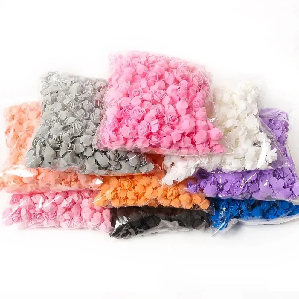A collection of artificial foam rose flowers in various shades including pink, gray, white, orange, purple, and blue.