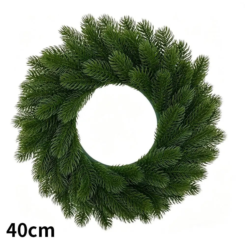A green artificial Christmas wreath with red berries and a velvet bow.