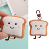 A soft, fluffy toast bread plush charm with a brown crust and white interior, attached to a metal keyring.